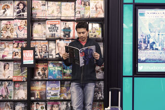 man reading a magazine in our media section - hudson store