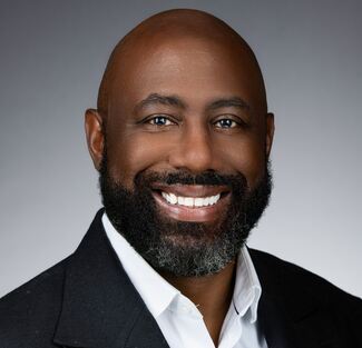 Man wearing a white dress shirt and black suit.