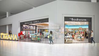 Travelers walk passed a retail store in an airport