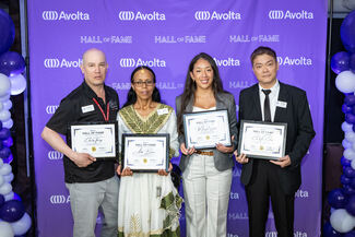 Four team members stand in front of a purple background that says Avolta Hall of Fame.