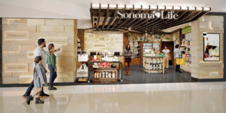 3 people walk by an airport store